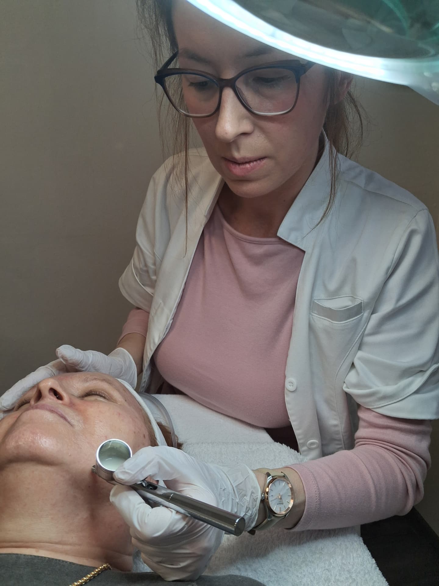 Kozmetológ aplikuje kyslíkové ošetrenie DermaOXY na pleť klientky