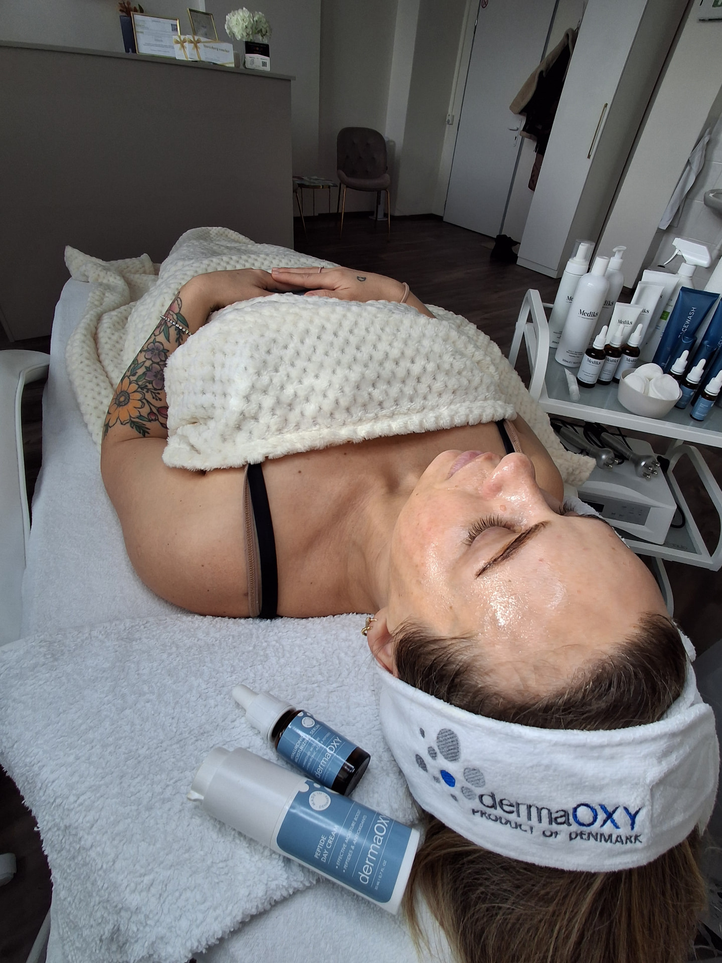 Klientka počas ošetrenia s dermaOXY čelenkou a produktmi
